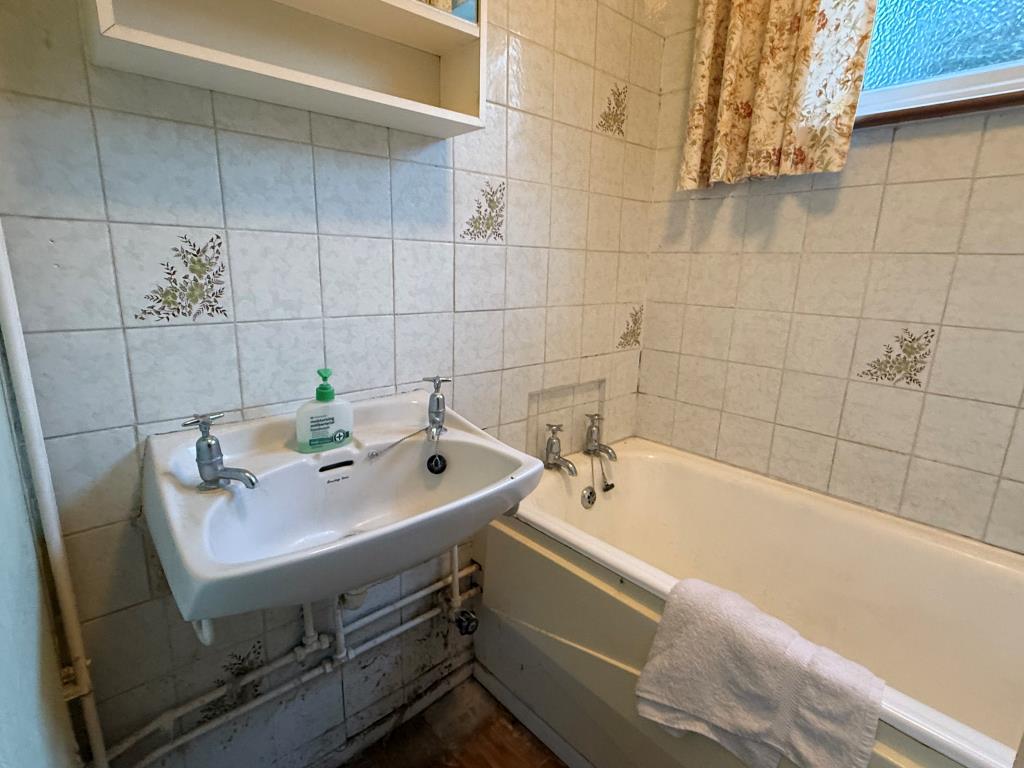 Lot: 154 - TWO-BEDROOM END-TERRACE HOUSE FOR IMPROVEMENT - Tiled bathroom with sink and bath